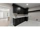 Stylish bar area with black cabinets, gold fixtures, and marble tile flooring at 1688 Mineral Springs Rd, Hoschton, GA 30548