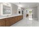 Bright bathroom with double vanity, illuminated mirrors, and marble floors offering a luxurious feel at 1688 Mineral Springs Rd, Hoschton, GA 30548