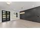 Dining room with hardwood floors, modern light fixture, black accent wall and glass paneled french doors at 1688 Mineral Springs Rd, Hoschton, GA 30548