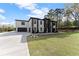 A modern house with a two-car garage and landscaped grounds on a sunny day at 1688 Mineral Springs Rd, Hoschton, GA 30548