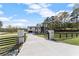 Stunning modern two-story home with a gated entrance and a long driveway in a lush, green setting at 1688 Mineral Springs Rd, Hoschton, GA 30548