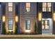 Close-up of a modern brick home exterior featuring designer lighting and manicured landscaping at 1688 Mineral Springs Rd, Hoschton, GA 30548