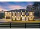 Striking two-story home with multi-car garage and professional landscaping at dusk at 1688 Mineral Springs Rd, Hoschton, GA 30548