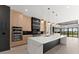 Open-concept kitchen featuring a large island, modern appliances, and wood cabinets at 1688 Mineral Springs Rd, Hoschton, GA 30548