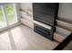 Modern living room with an electric fireplace, custom shelving and large windows at 1688 Mineral Springs Rd, Hoschton, GA 30548