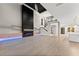 Open-concept living area with modern fireplace, staircase, and kitchen in a brightly lit space at 1688 Mineral Springs Rd, Hoschton, GA 30548