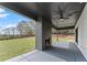 Covered patio features a brick fireplace, ceiling fan, and views of the backyard at 1688 Mineral Springs Rd, Hoschton, GA 30548