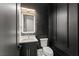 Modern powder room with stylish fixtures, vanity, and dark accent wall at 1688 Mineral Springs Rd, Hoschton, GA 30548