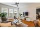 Comfortable living room with large windows, a ceiling fan, and a modern entertainment center at 1850 Cotillion Dr # 2221, Atlanta, GA 30338