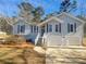 Charming light blue home with a two-car garage and steps leading to the front door at 3113 Shiloh Pl, Canton, GA 30115