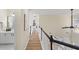 Upstairs hallway with wood floors and black and white railing, leading to bedrooms and bathrooms at 3286 Sir Henry St, Atlanta, GA 30344