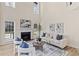 Bright living room with fireplace, large windows, light wood floors, and soaring ceilings at 3286 Sir Henry St, Atlanta, GA 30344