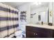 A bathroom with a striped shower curtain, a granite countertop, and a vanity with dark brown wood at 103 Cottage Way, Euharlee, GA 30145
