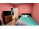 Bedroom featuring a bed, a pink wall, and a TV on a dresser at 113 Citadel Dr, Hampton, GA 30228