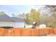 Wooden playground with slide and swing set in a fenced backyard with pool in view at 113 Citadel Dr, Hampton, GA 30228