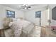 Bright bedroom with wood flooring, two windows, ceiling fan, and a large bed with floral bedding at 570 Harris Sw Ct, Marietta, GA 30060