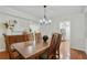 Classic dining room with wooden table, decorative chandelier, and view of the kitchen at 6851 Roswell Rd # D-6, Atlanta, GA 30328