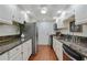 Galley kitchen with granite counters, white cabinets, and stainless steel appliances at 6851 Roswell Rd # D-6, Atlanta, GA 30328