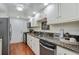 Well-lit kitchen featuring granite countertops, white cabinets, and a stainless steel refrigerator at 6851 Roswell Rd # D-6, Atlanta, GA 30328