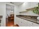Bright kitchen featuring granite countertops, white cabinets, and view into the dining room at 6851 Roswell Rd # D-6, Atlanta, GA 30328