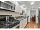 Modern kitchen with granite countertops, white cabinets, and stainless steel gas range at 6851 Roswell Rd # D-6, Atlanta, GA 30328