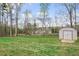 Lush backyard with mature trees and a storage shed, offering privacy and functionality at 121 Tricias Way, Temple, GA 30179