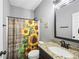 Bathroom with single vanity, tile floors, and a shower with a sunflower-themed shower curtain at 121 Tricias Way, Temple, GA 30179