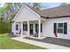 Charming single-story home featuring gray vinyl siding, black shutters, and a welcoming front porch with rocking chairs at 121 Tricias Way, Temple, GA 30179