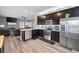 Open kitchen with stainless appliances, granite counters, and dark wood cabinets flows into living area at 121 Tricias Way, Temple, GA 30179