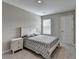 Cozy bedroom featuring a comfortable bed, neutral decor, and natural light from the window at 2220 Lanier Harbor Pt, Buford, GA 30518