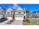 Attractive townhome boasts a two-car garage, landscaping, and a welcoming facade at 2220 Lanier Harbor Pt, Buford, GA 30518