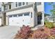Close up of Townhome entrance with large garage and manicured landscaping at 2220 Lanier Harbor Pt, Buford, GA 30518
