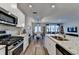 Open kitchen with stainless appliances, granite countertops, and an island flows into living at 2220 Lanier Harbor Pt, Buford, GA 30518