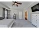 Well-lit main bedroom featuring a tray ceiling, ceiling fan, and ensuite bathroom at 2220 Lanier Harbor Pt, Buford, GA 30518