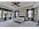 Spacious main bedroom featuring tray ceiling, ceiling fan, large windows, and gray curtains at 2220 Lanier Harbor Pt, Buford, GA 30518