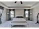 Inviting main bedroom with tray ceiling, ceiling fan, and soft gray carpeting at 2220 Lanier Harbor Pt, Buford, GA 30518