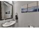 Well decorated powder room with pedestal sink, framed mirror, and mountain landscape art at 2220 Lanier Harbor Pt, Buford, GA 30518