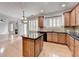 Spacious kitchen features an island, wooden cabinets, granite countertops, and stainless steel appliances at 2723 Ivy Bluff Ct, Buford, GA 30519