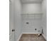 Empty laundry room with tile floor, wall, and hookups ready for appliances at 2723 Ivy Bluff Ct, Buford, GA 30519