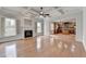 Open concept living room with fireplace, hardwood floors, coffered ceiling, and view into kitchen at 2723 Ivy Bluff Ct, Buford, GA 30519