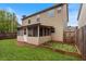 Backyard featuring a screened in porch, green grass and wooden privacy fence at 461 Summerstone Ln, Lawrenceville, GA 30044