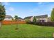 Large grassy backyard with trees and a wooden fence separating it from neighboring homes at 461 Summerstone Ln, Lawrenceville, GA 30044