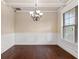 Formal dining room featuring hardwood floors, wainscoting, and a stylish chandelier at 461 Summerstone Ln, Lawrenceville, GA 30044