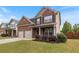Charming two-story brick home with dark shutters, manicured lawn, and a two-car garage at 461 Summerstone Ln, Lawrenceville, GA 30044