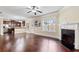 Open-concept living room with hardwood floors, fireplace, and kitchen in the background at 461 Summerstone Ln, Lawrenceville, GA 30044