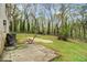 Expansive backyard with a concrete patio area, lush grass, and mature trees at 626 Mincey Ct, Stone Mountain, GA 30087