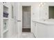 A white bathroom with granite floors, a large vanity and built in linen closet at 626 Mincey Ct, Stone Mountain, GA 30087