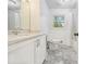 A white bathroom with granite floors, a white vanity and a shower tub combo at 626 Mincey Ct, Stone Mountain, GA 30087