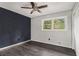 Cozy bedroom featuring wood-look floors, a dark accent wall and a ceiling fan at 626 Mincey Ct, Stone Mountain, GA 30087