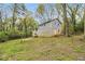 Back exterior view of the brick home surrounded by mature trees at 626 Mincey Ct, Stone Mountain, GA 30087